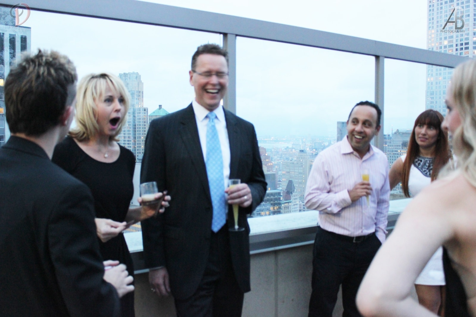 A guest open-mouthed in shock during Chris Dare's close-up magic at a rooftop party