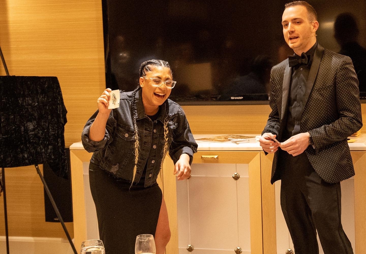 A guest laughing while holding a signed card during a private suite performance