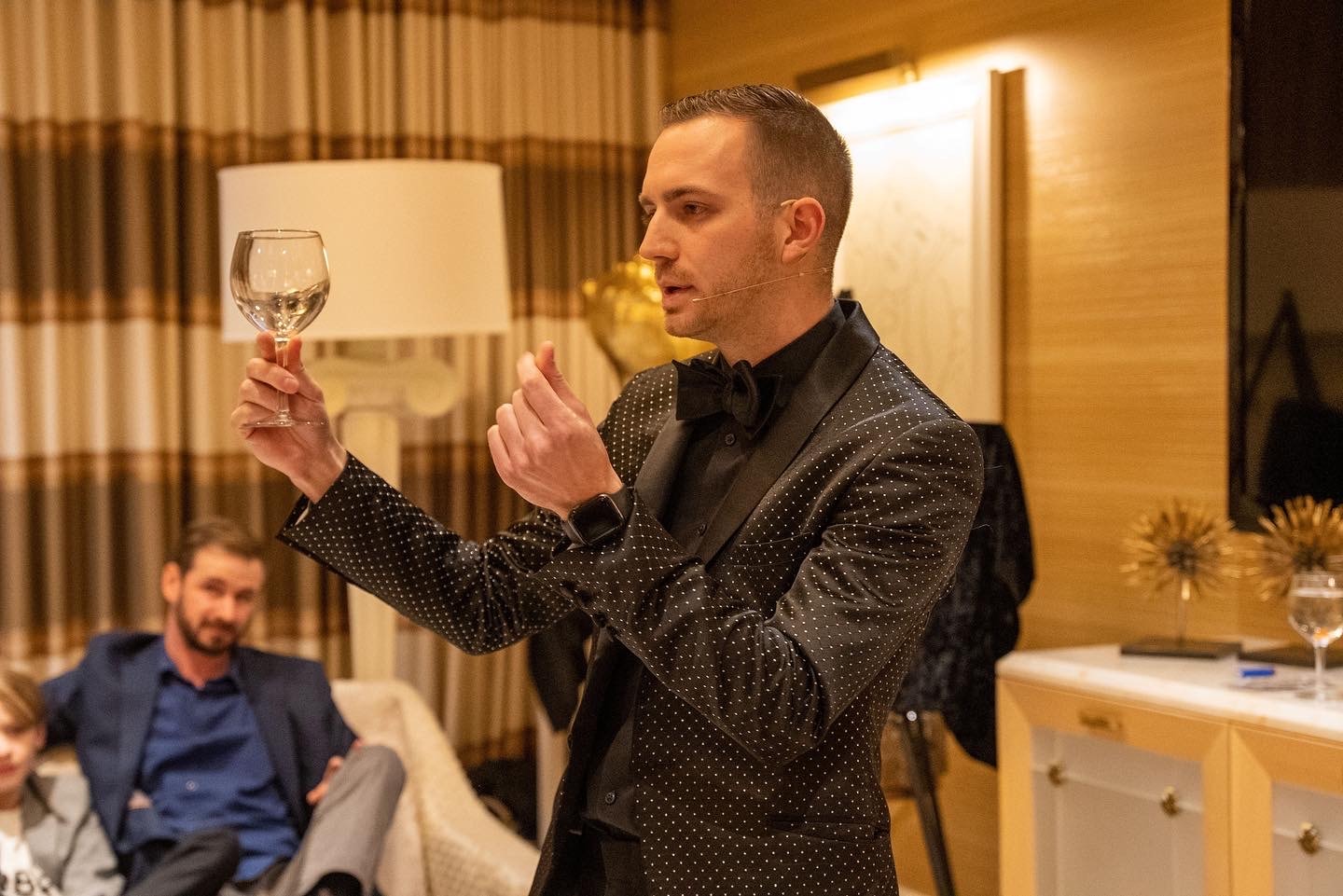 Chris Dare performing a levitating glass illusion at a private suite show
